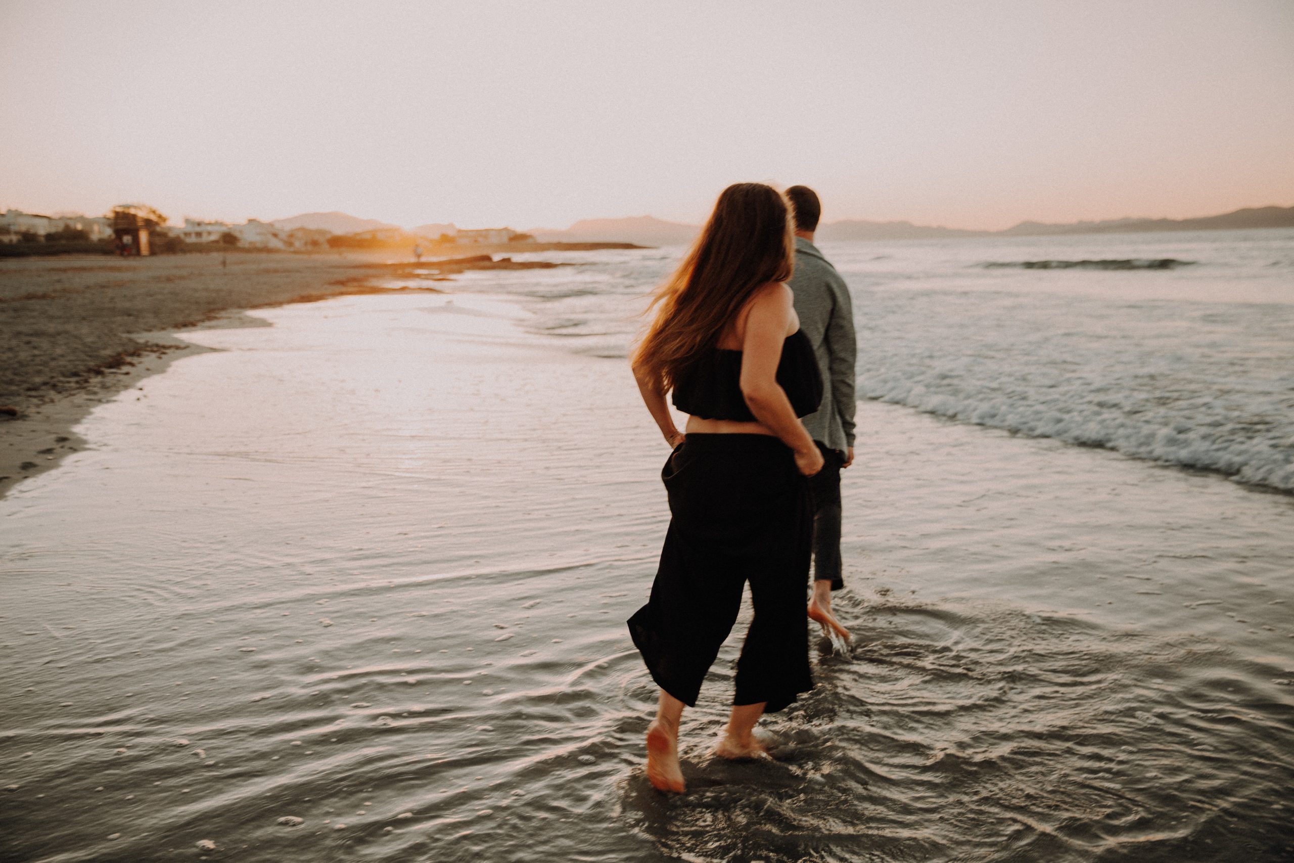 Romantisches Couple Shooting bei Sonnenuntergang – Paar spaziert barfuß am Wasser im Licht der untergehenden Sonne