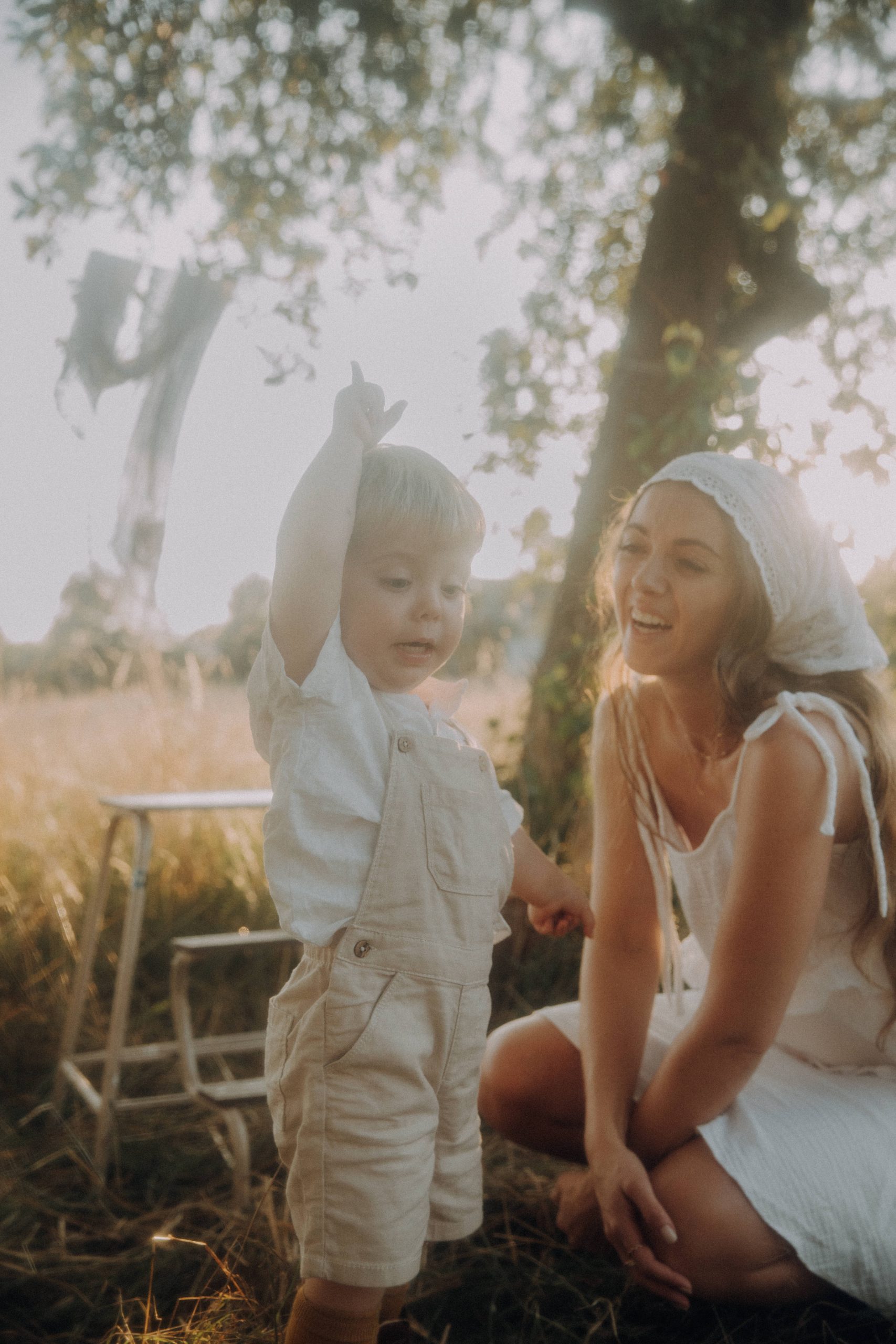 Mutter lächelt ihr Kind im warmen Abendlicht an