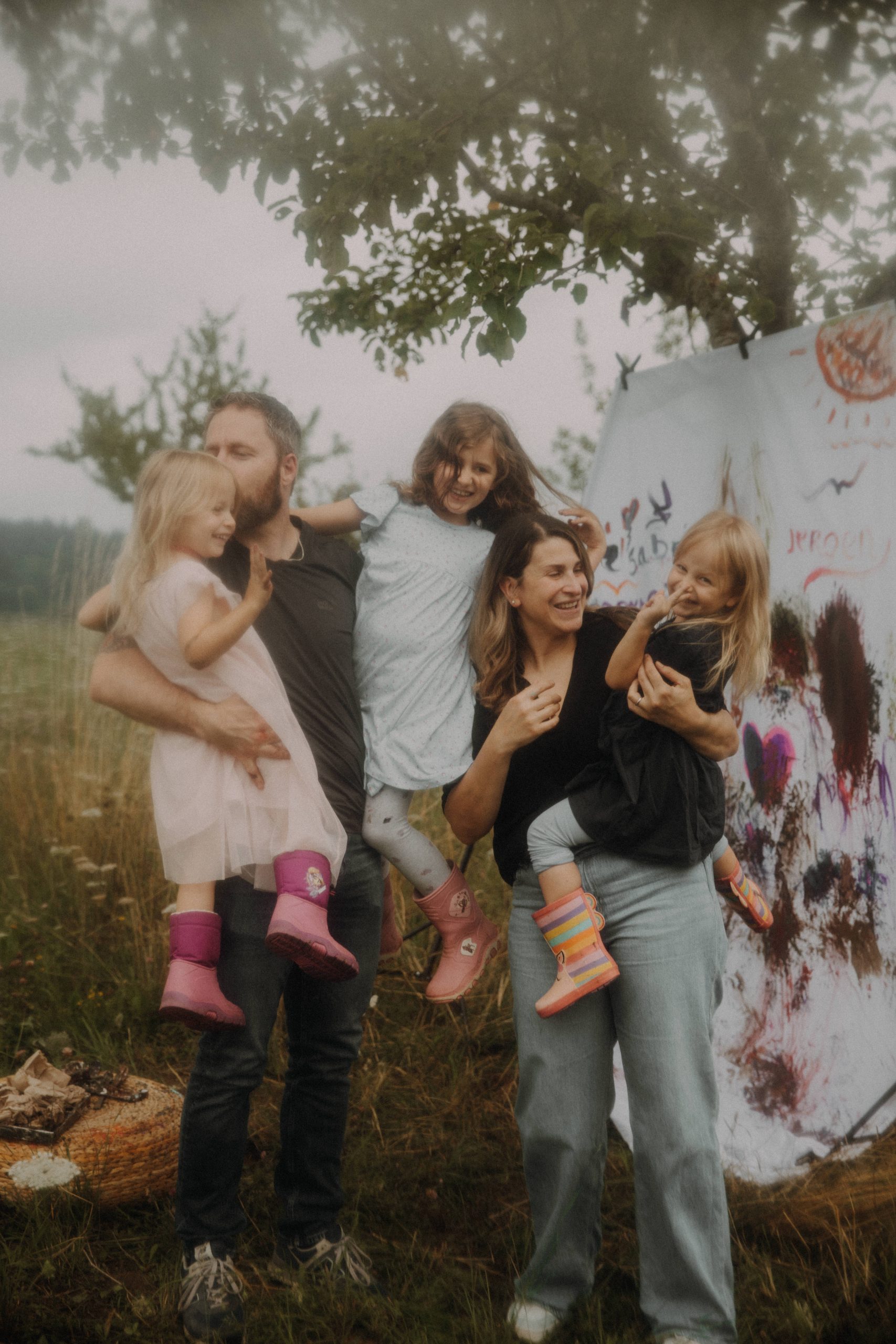 Fröhliche Familie mit drei Kindern auf einer Wiese