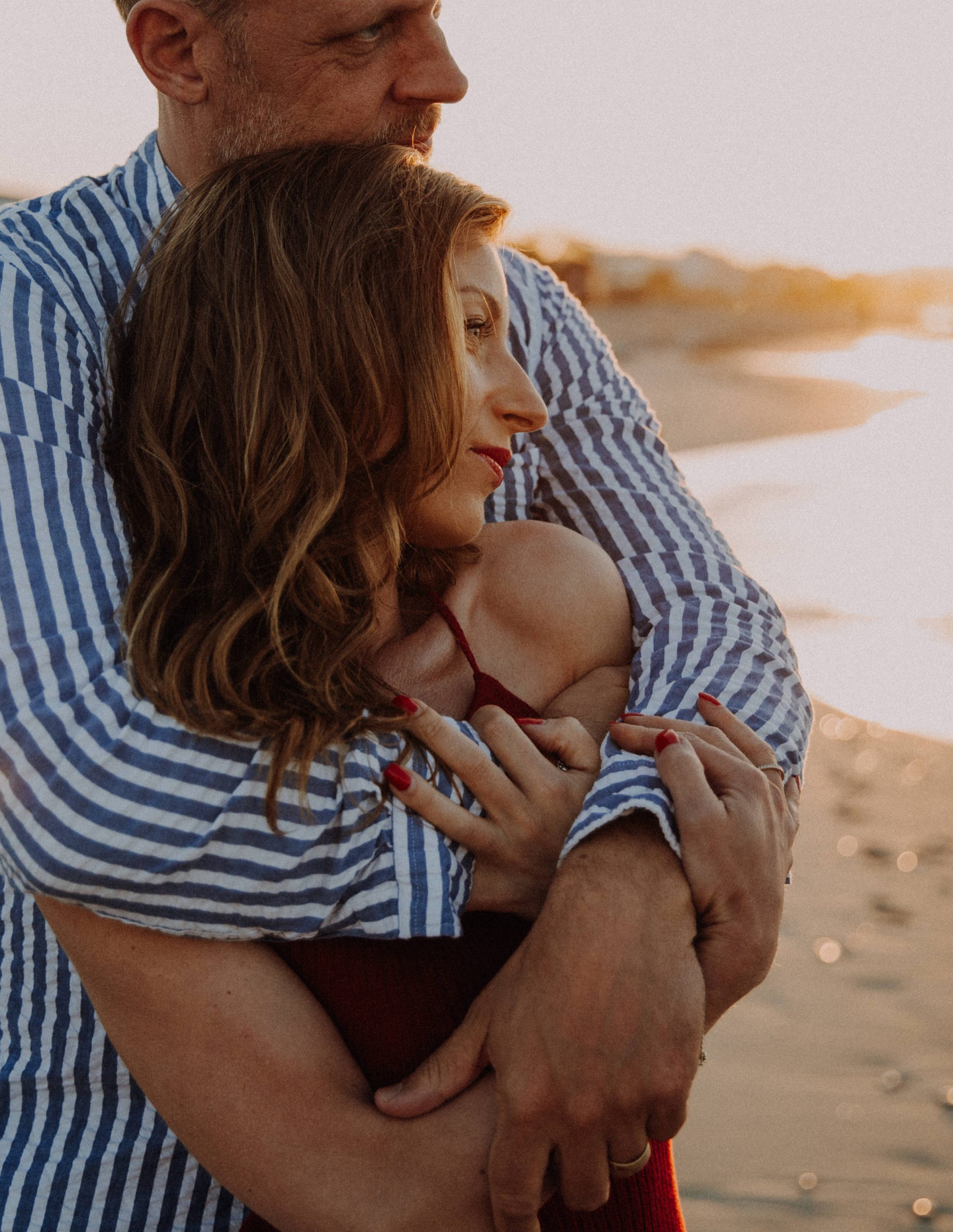 Paarshooting am Wasser – Paar in inniger Umarmung im goldenen Sonnenuntergang