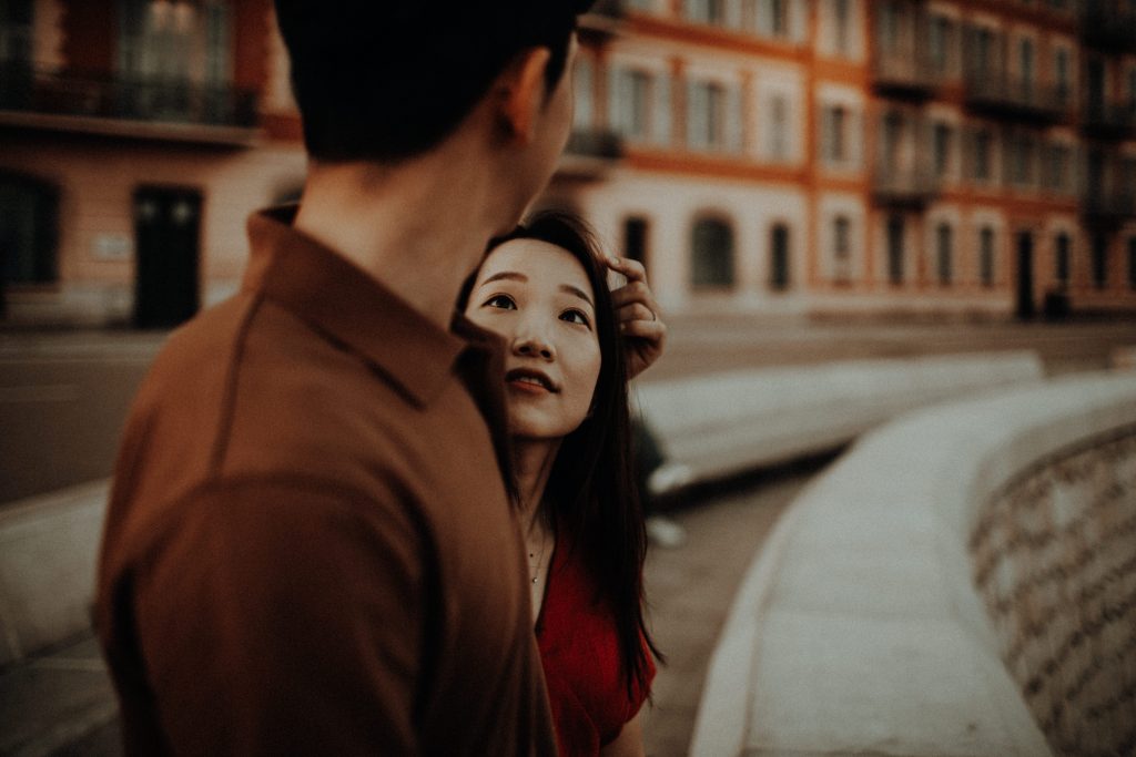 Intimes Urban Couple Shooting – Frau blickt Partner liebevoll an vor warmer Altstadtkulisse