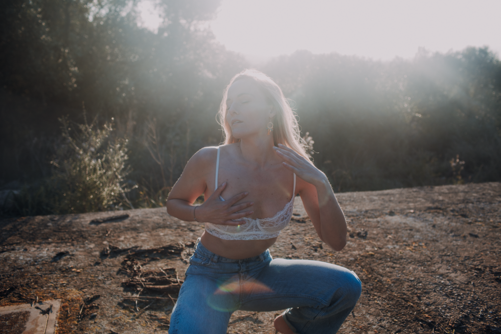 Empowerndes Outdoor Boudoir Shooting – Frau in Spitzen-BH und Jeans im strahlenden Sonnengegenlicht, selbstbewusst und kraftvoll