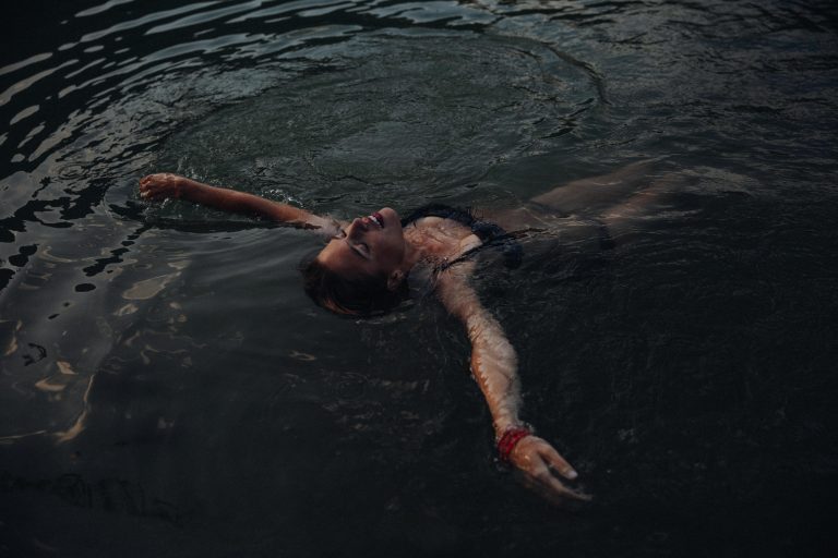 Fine Art Boudoir Shooting Outdoor – Frau schwebt im dunklen Wasser, dramatische und mystische Bildsprache