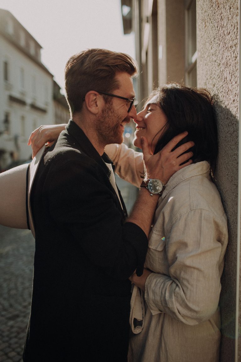 Romantisches Urban Couple Shooting – verliebtes Paar in innigem Moment in europäischer Altstadtgasse im Sonnenlicht