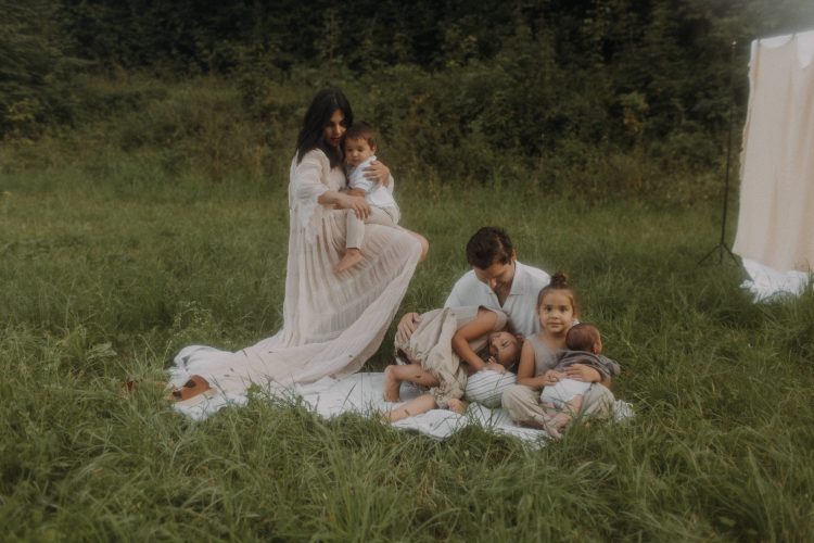 Familienfotografie mit Baby, 6-köpfige Familie auf einer Wiese mit Picknickatmosphäre